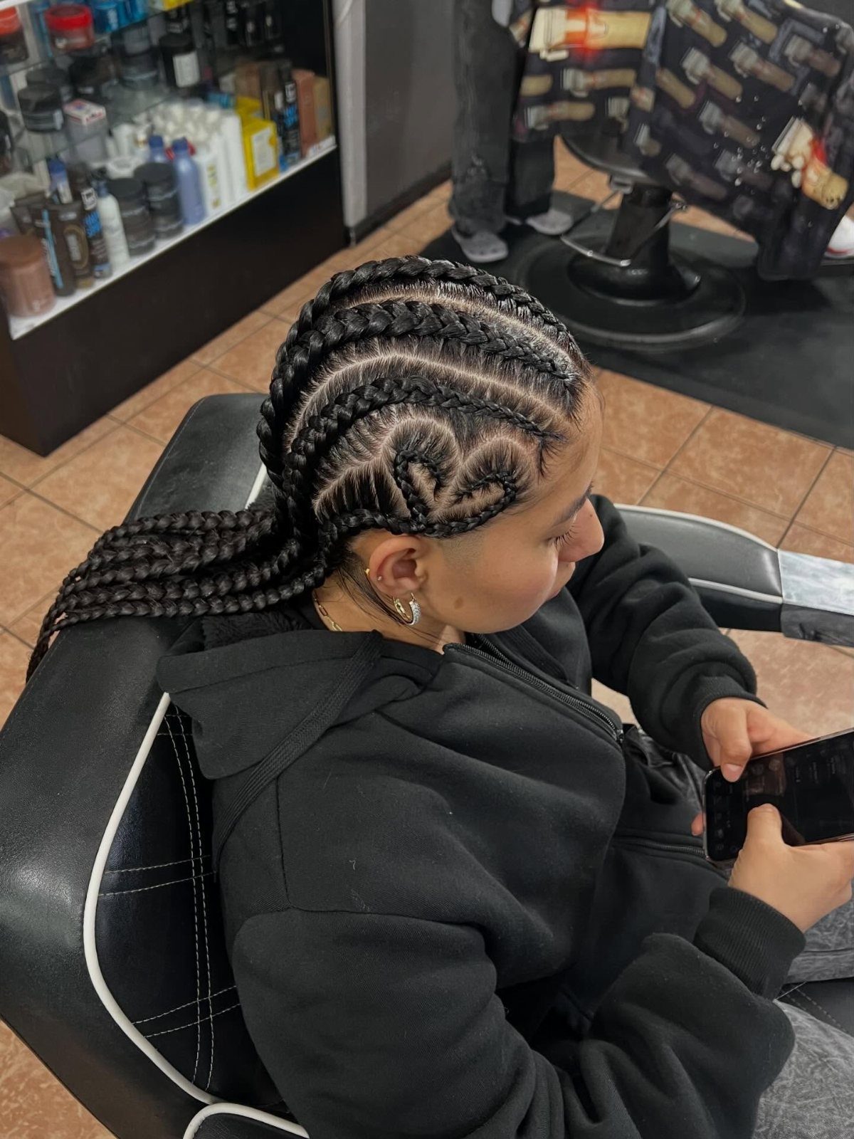 Young person with cornrow braids featuring a heart-shaped braid on the side.