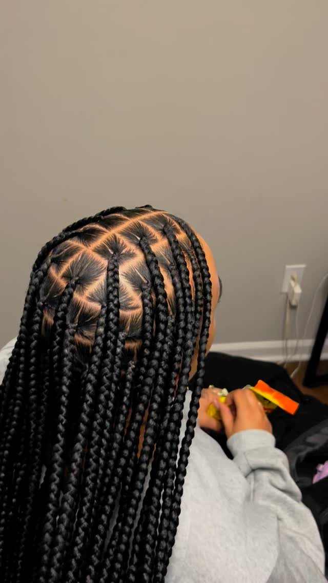 Long black box braids with square parting on a person's head.
