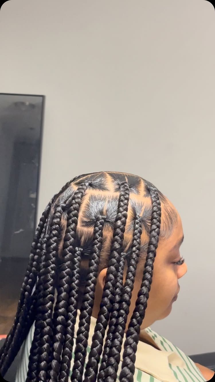 Person with long black box braids and neat square scalp sections in profile