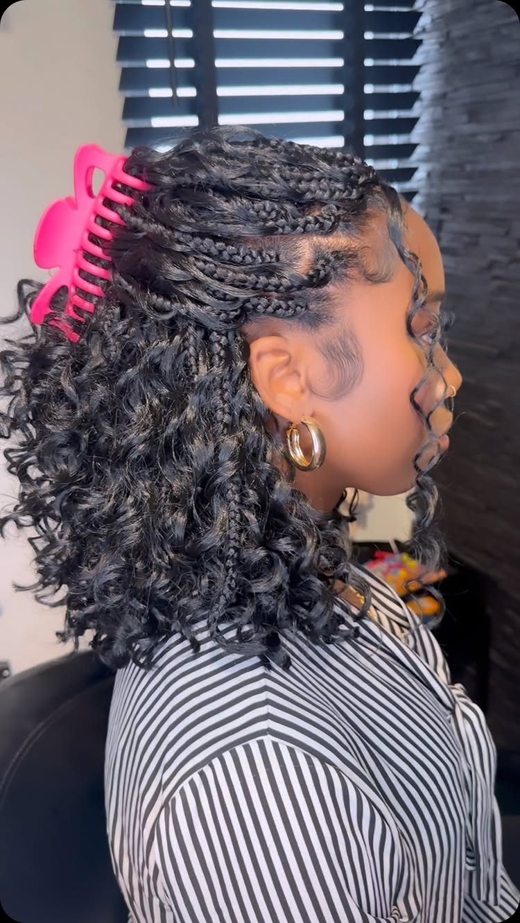 Woman with a braided bob hairstyle featuring curly ends and a pink clip.