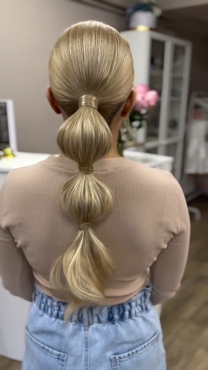 Blonde hair styled in a bubble braid ponytail from a back view.