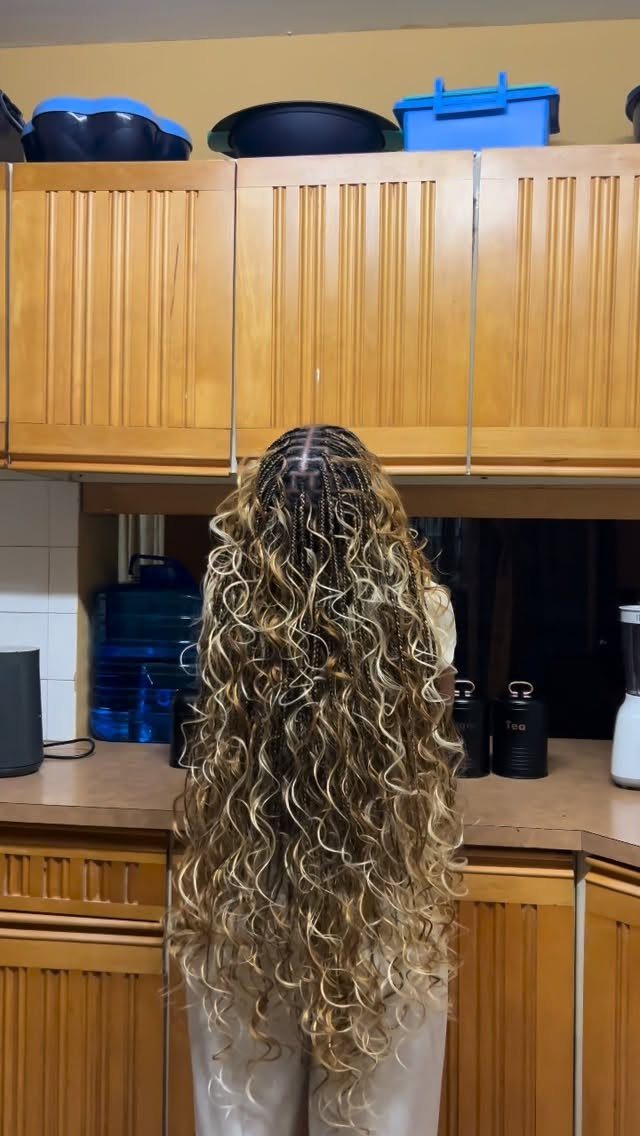 Long blonde and brown goddess braids with cornrows and loose curly tendrils.