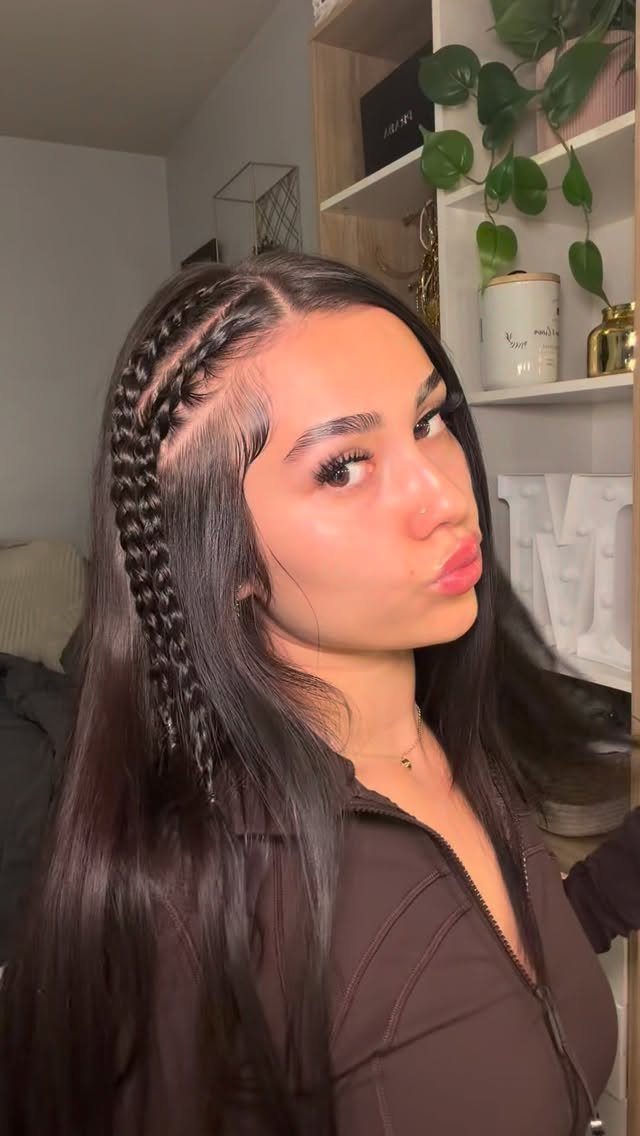 Woman with long dark hair featuring a thick side braid and styled edges.