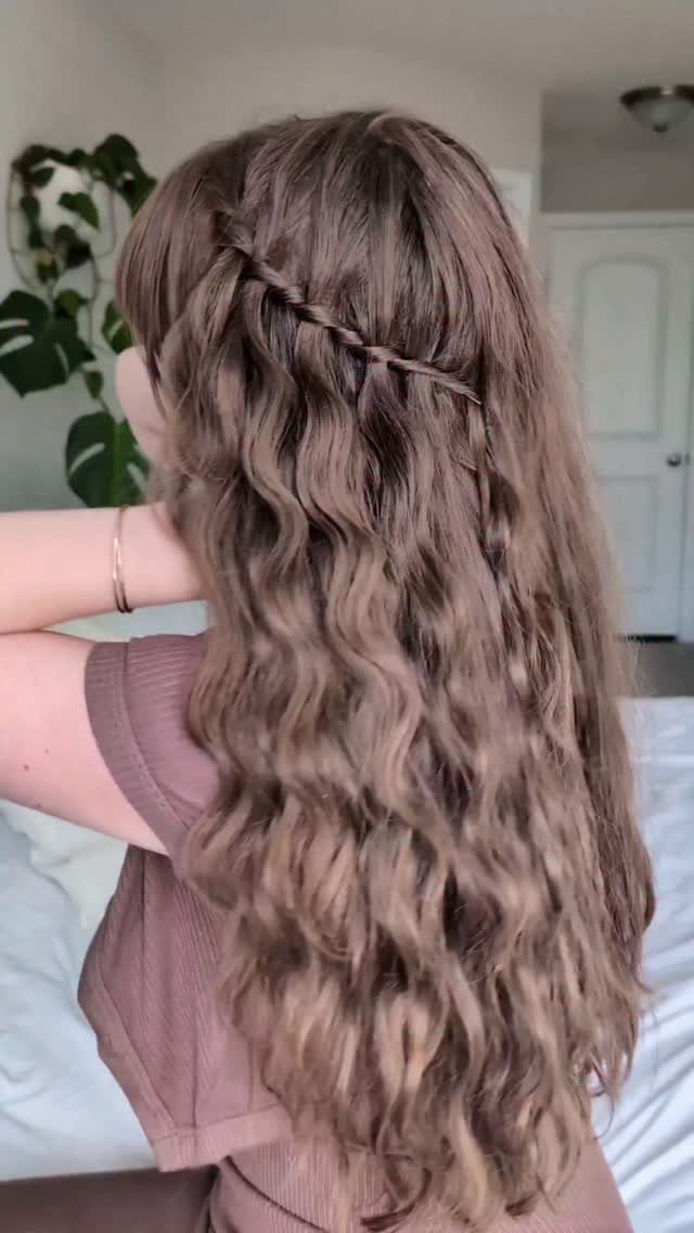 Long wavy brown hair featuring a horizontal waterfall braid across the back.