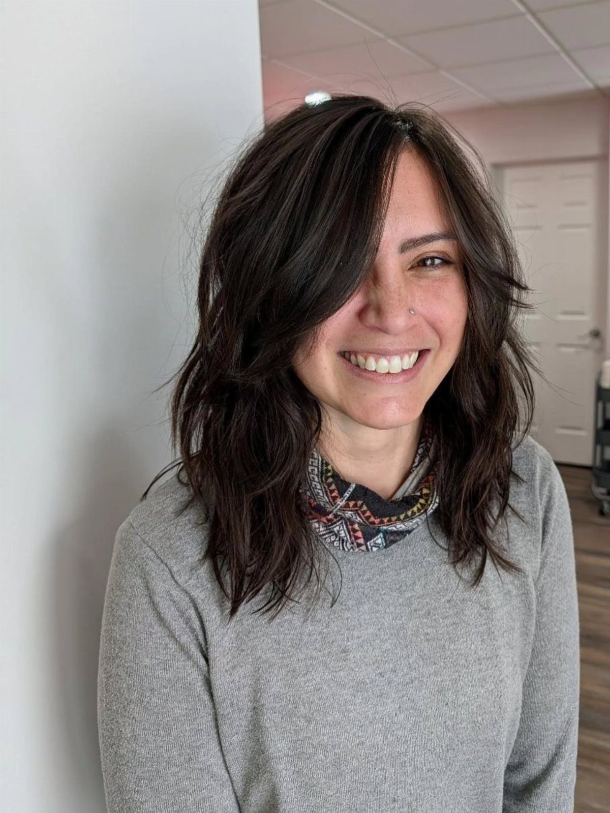 Woman with a medium length dark brown classic shag haircut and soft layers.