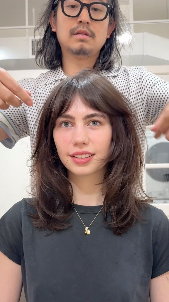 Woman with a soft wavy medium shag haircut and bangs in a salon