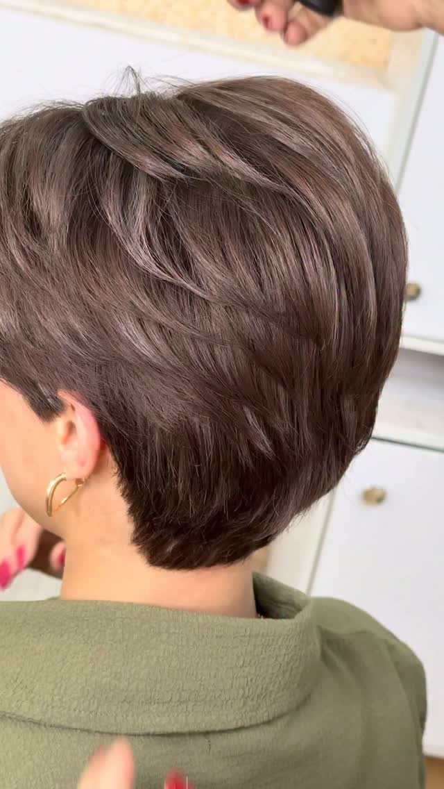 Woman with a short, textured tapered haircut in a muted brown shade.